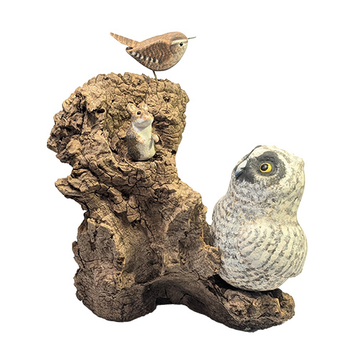 Carved wooden baby owl with mouse and small bird on a piece of driftwood.